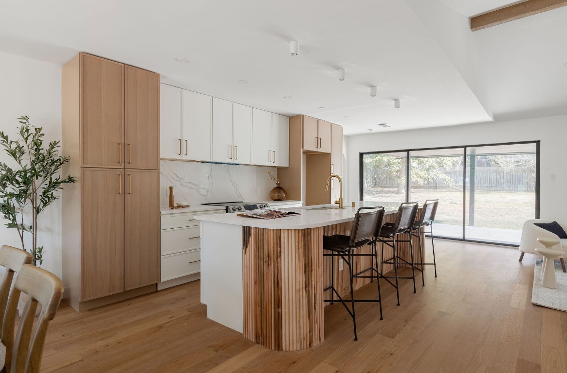 a kitchen with a stove a refrigerator and wooden floors