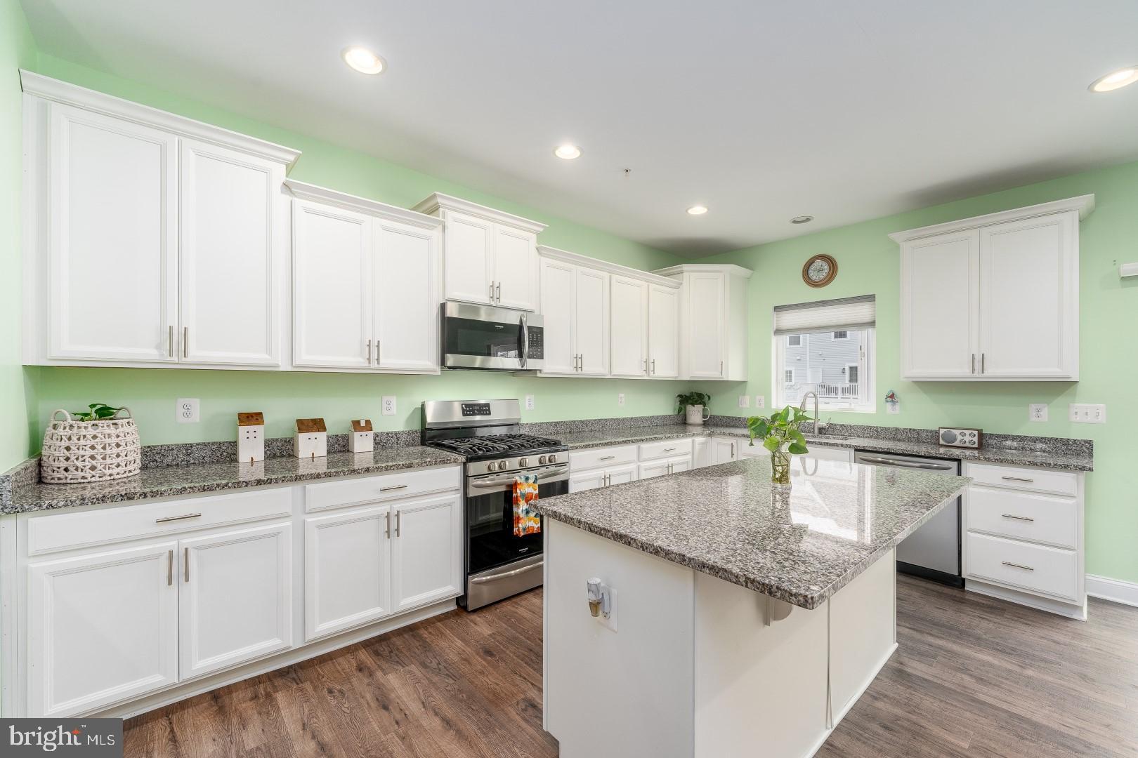 a kitchen with granite countertop white cabinets and white appliances