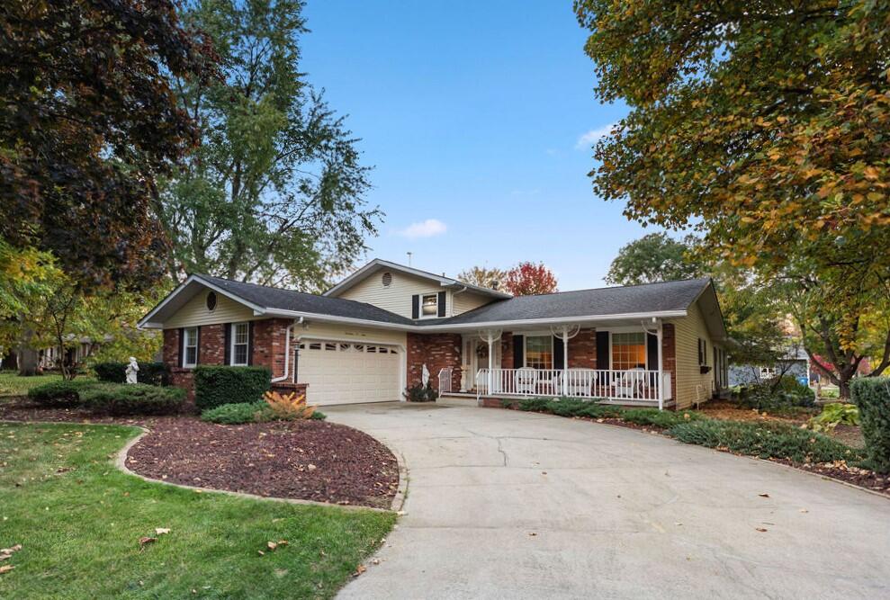 a front view of a house with a yard and trees