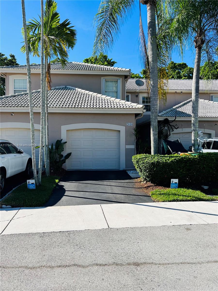 a view of a house with a yard and palm trees