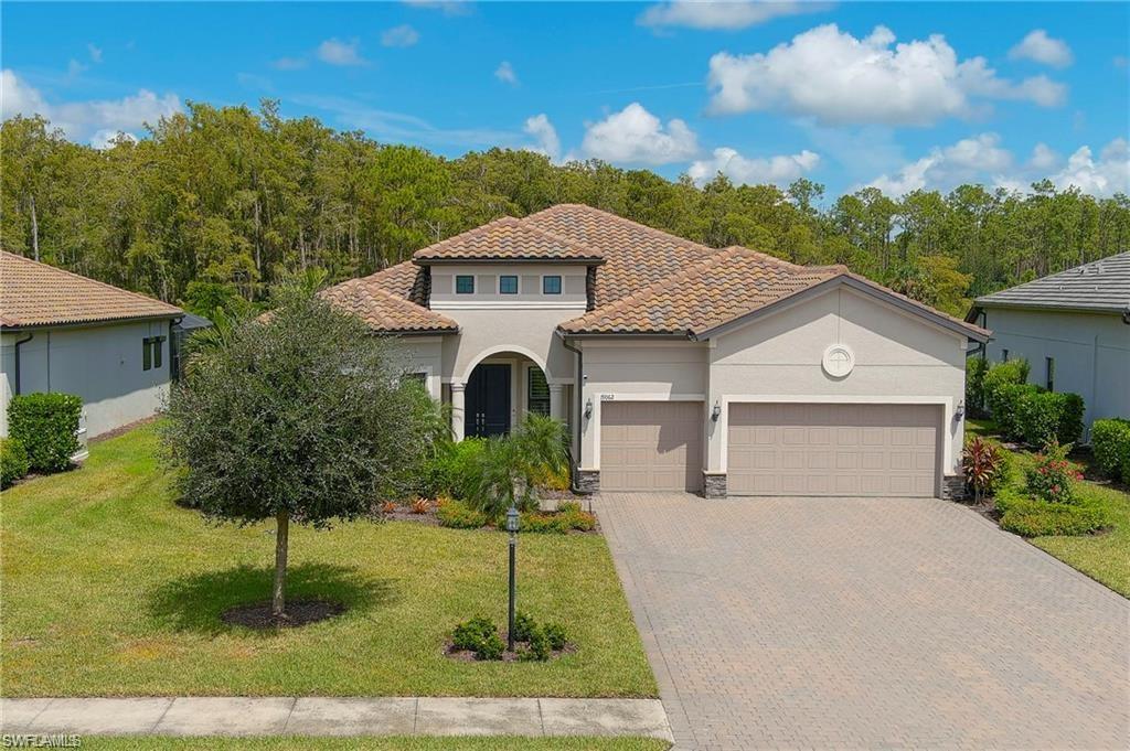 Mediterranean / spanish-style home with a front lawn and a garage