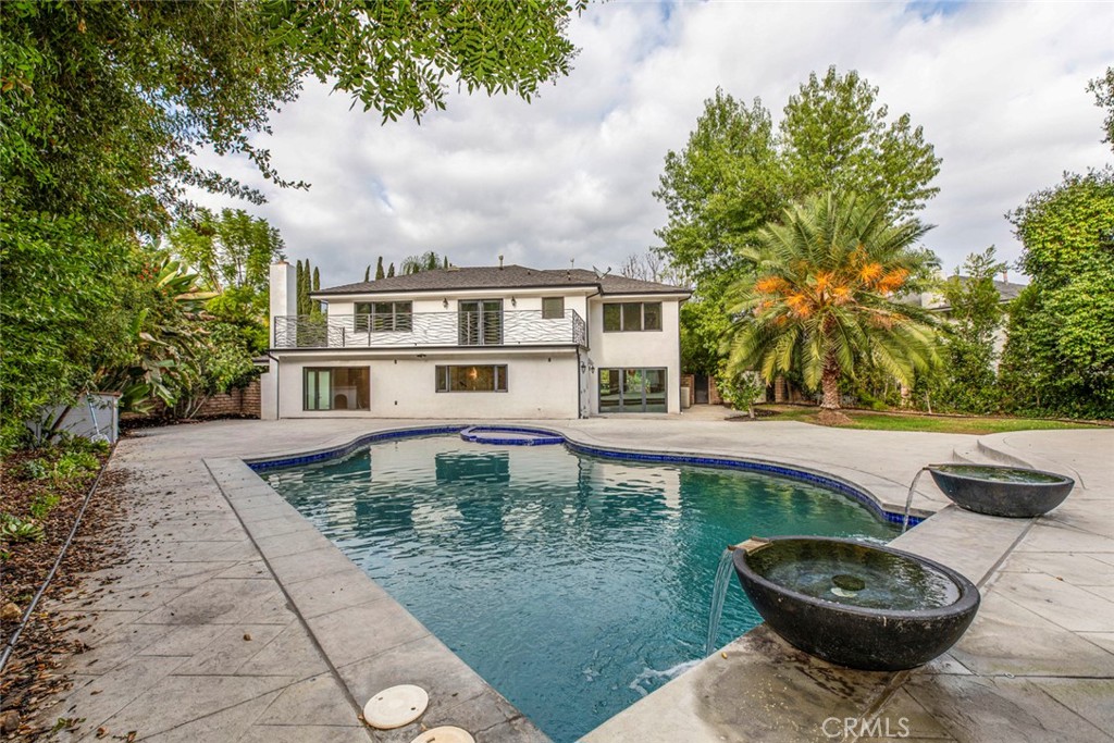 a view of a white house with a swimming pool and a yard