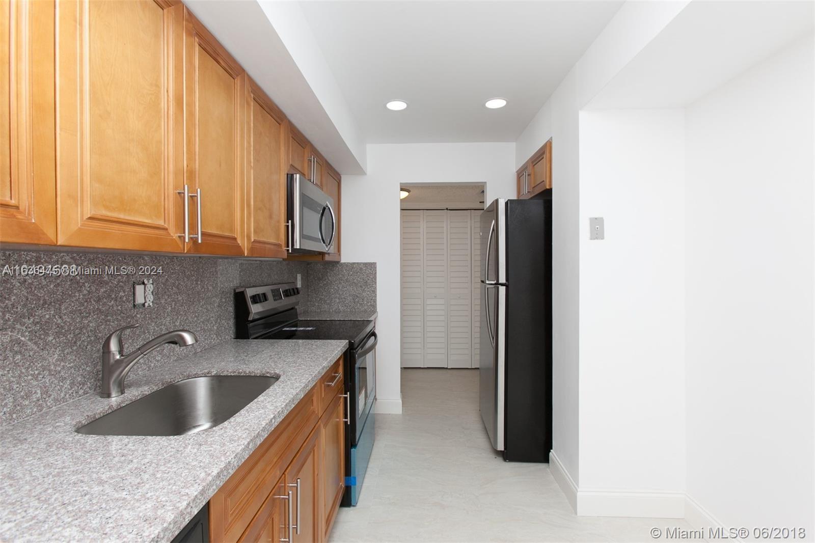 a kitchen with a sink a refrigerator and cabinets