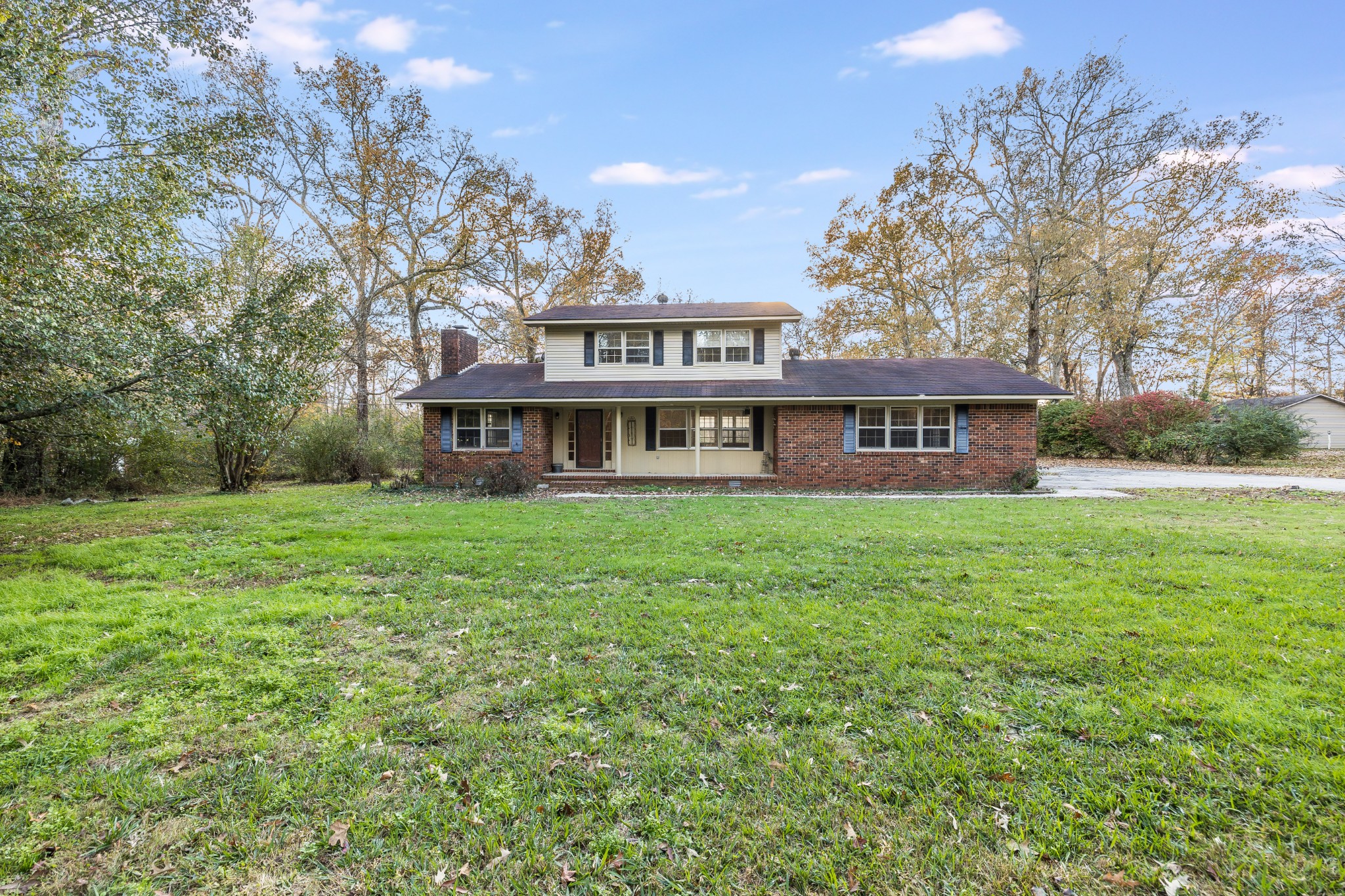 a front view of a house with garden and trees