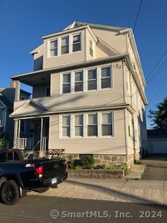 a black car is parked in front of a houses