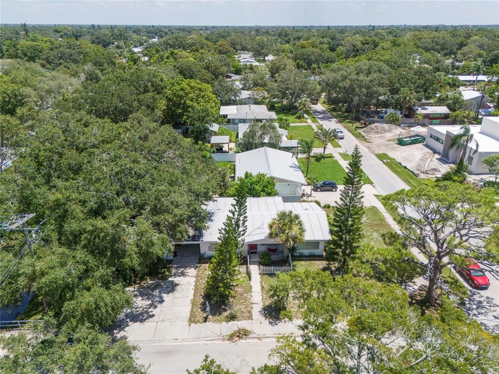 an aerial view of residential houses with outdoor space and trees