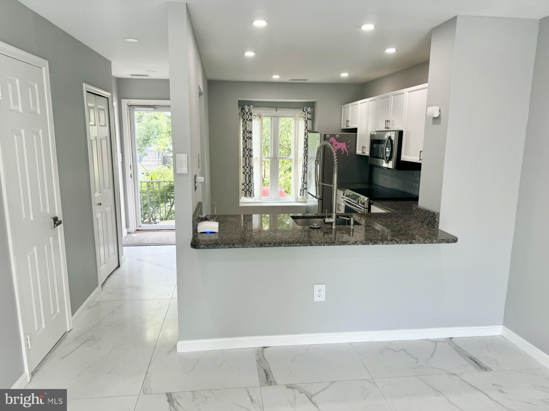 a living room with kitchen furniture and a open kitchen view