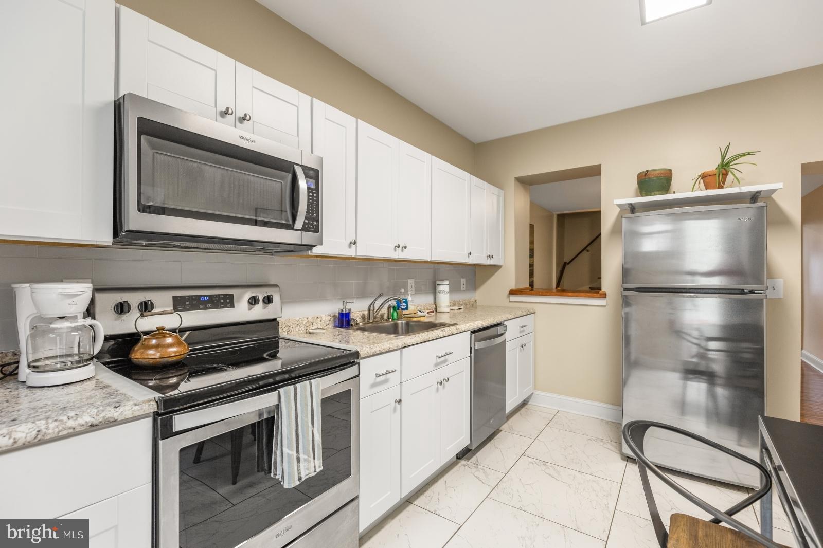 a kitchen with cabinets stainless steel appliances and wooden floor