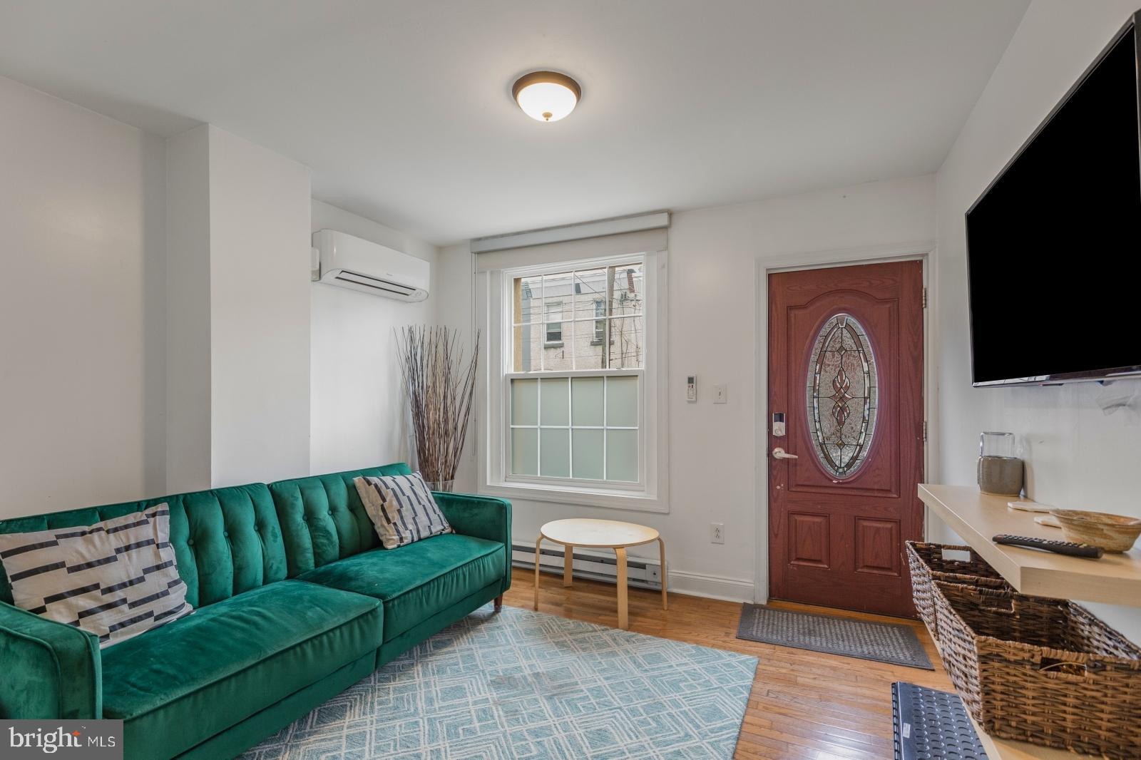 a living room with furniture a flat screen tv and kitchen view