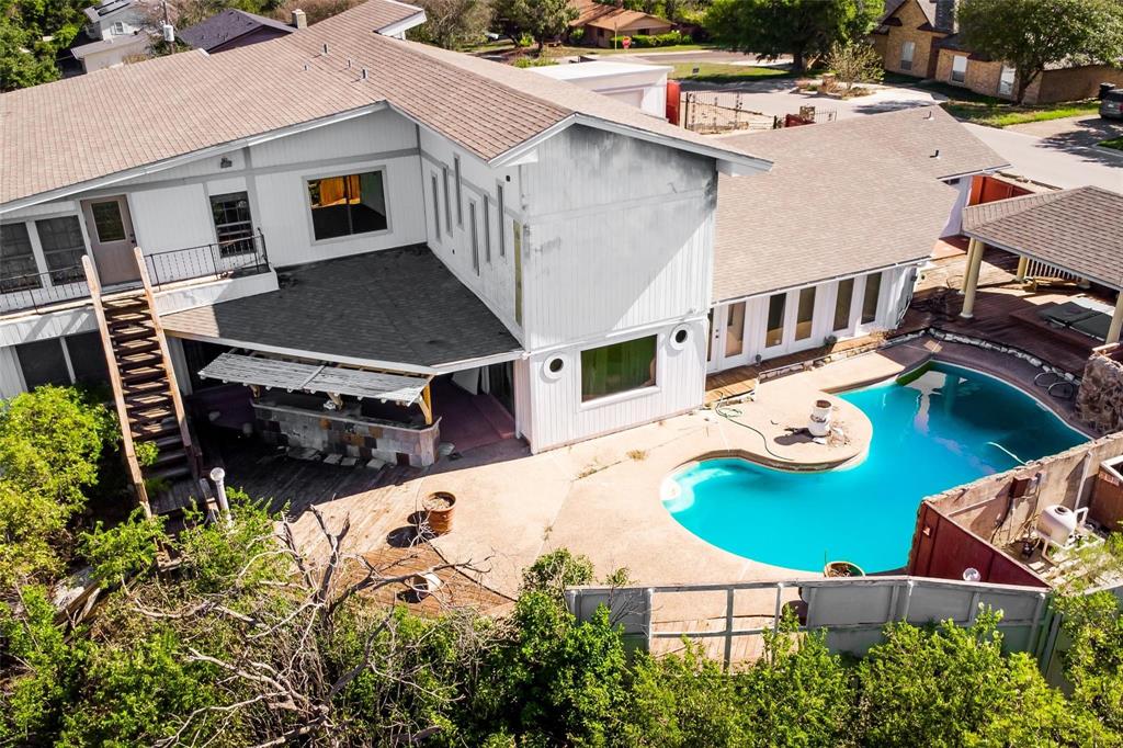 an aerial view of a house with swimming pool and patio