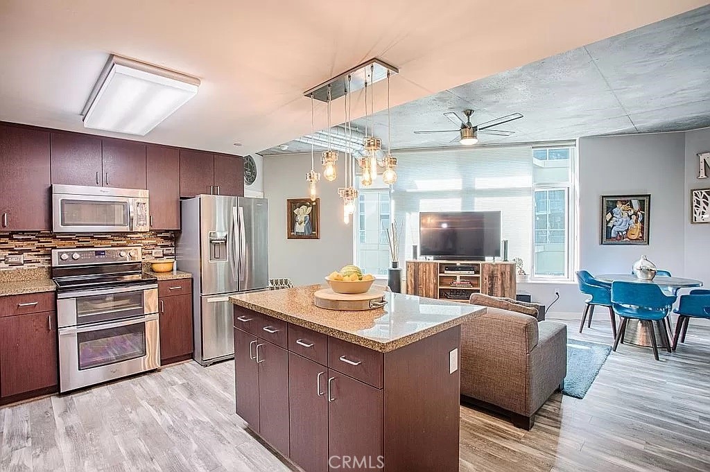 a kitchen with stainless steel appliances granite countertop a sink dishwasher stove and refrigerator