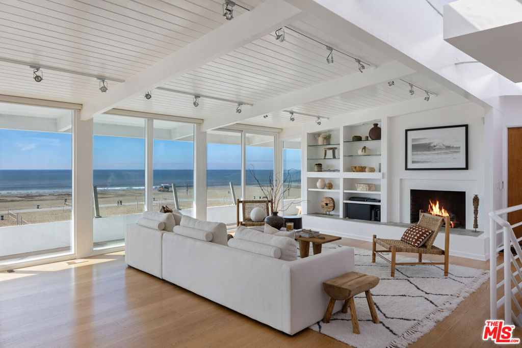 a living room with furniture large wooden floor and a fireplace