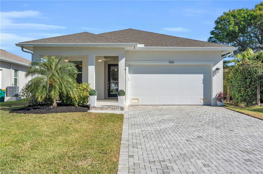 View of front of home featuring a garage, landscaping and new lighting