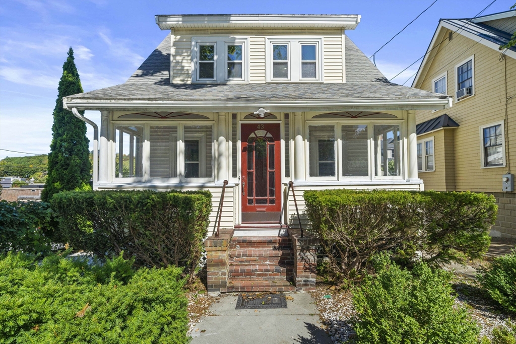 front view of a brick house with a small yard