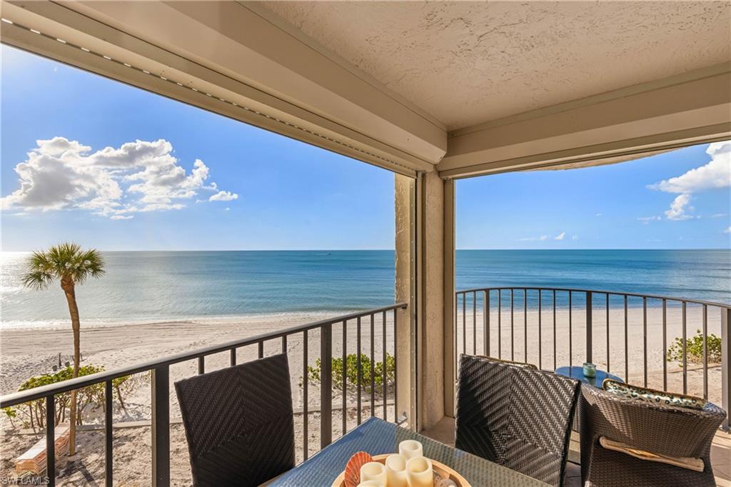 Balcony with a water view and a view of the beach