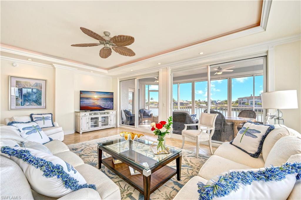 a living room with furniture a flat screen tv and a large window