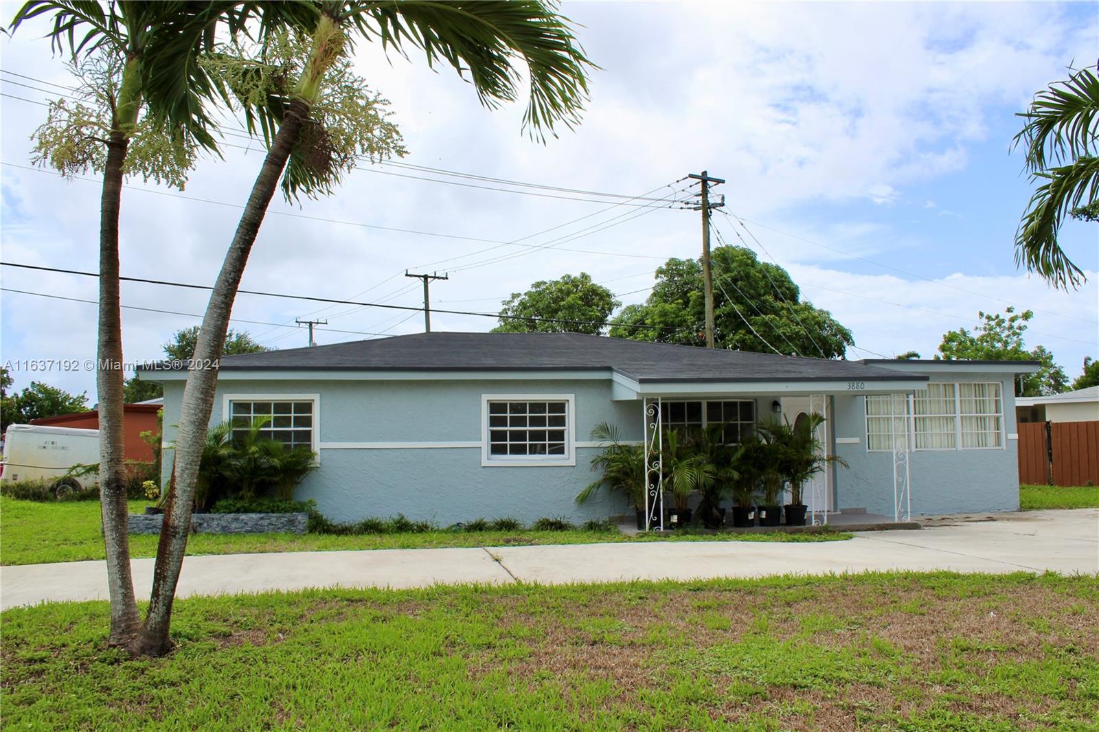 a front view of house with yard and potted plants