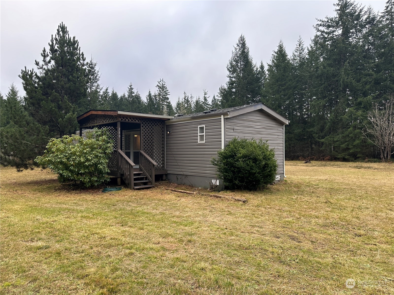 a view of a house with backyard and trees