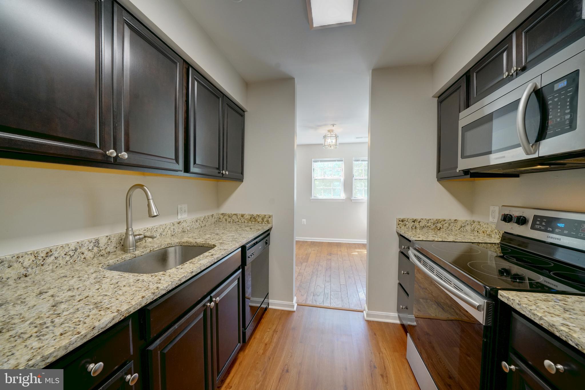 a kitchen with granite countertop stainless steel appliances and wooden cabinets