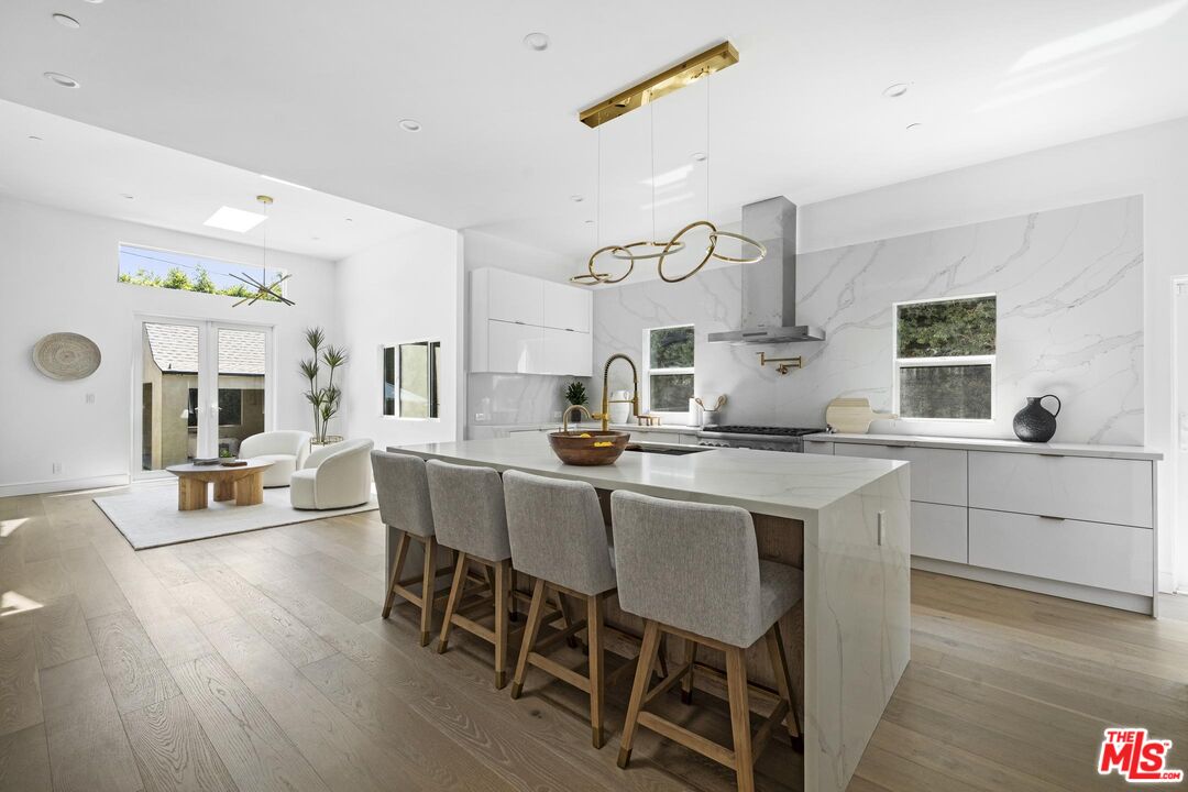 a kitchen with a dining table chairs wooden floor and appliances