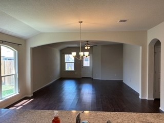 an entryway in a room with wooden floor chandelier and windows