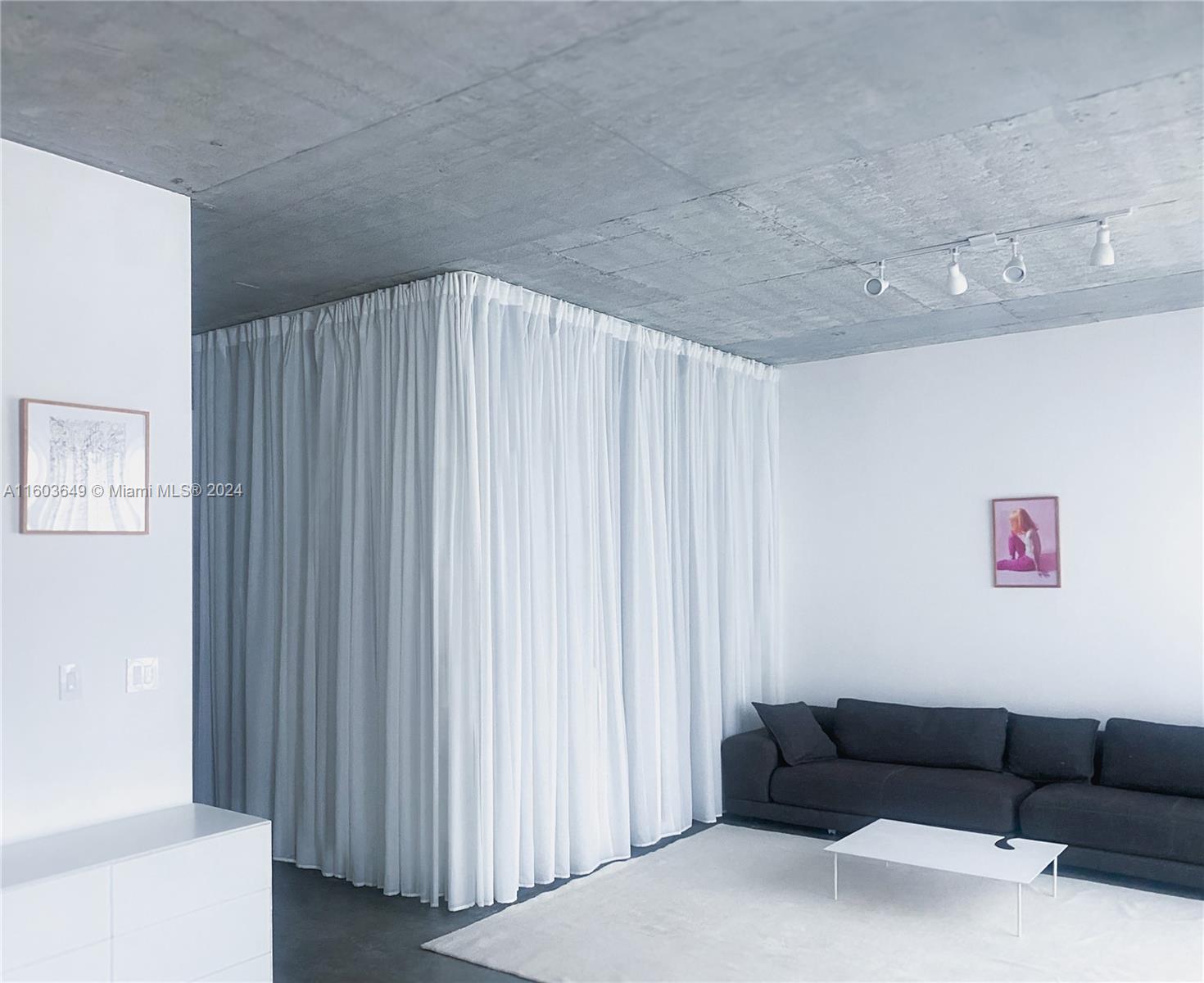 a living room with furniture and a curtain