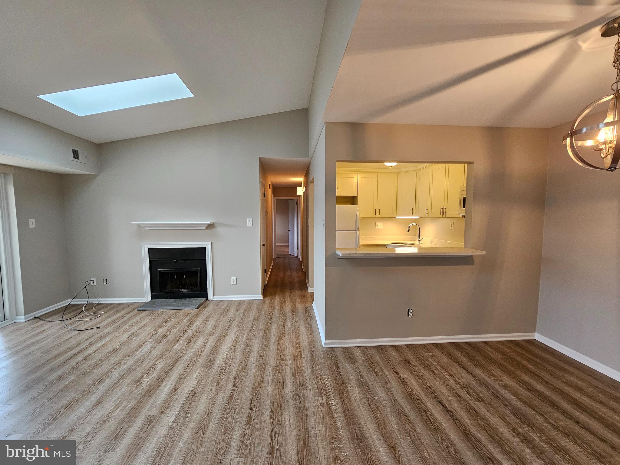 a view of empty room with wooden floor and fireplace