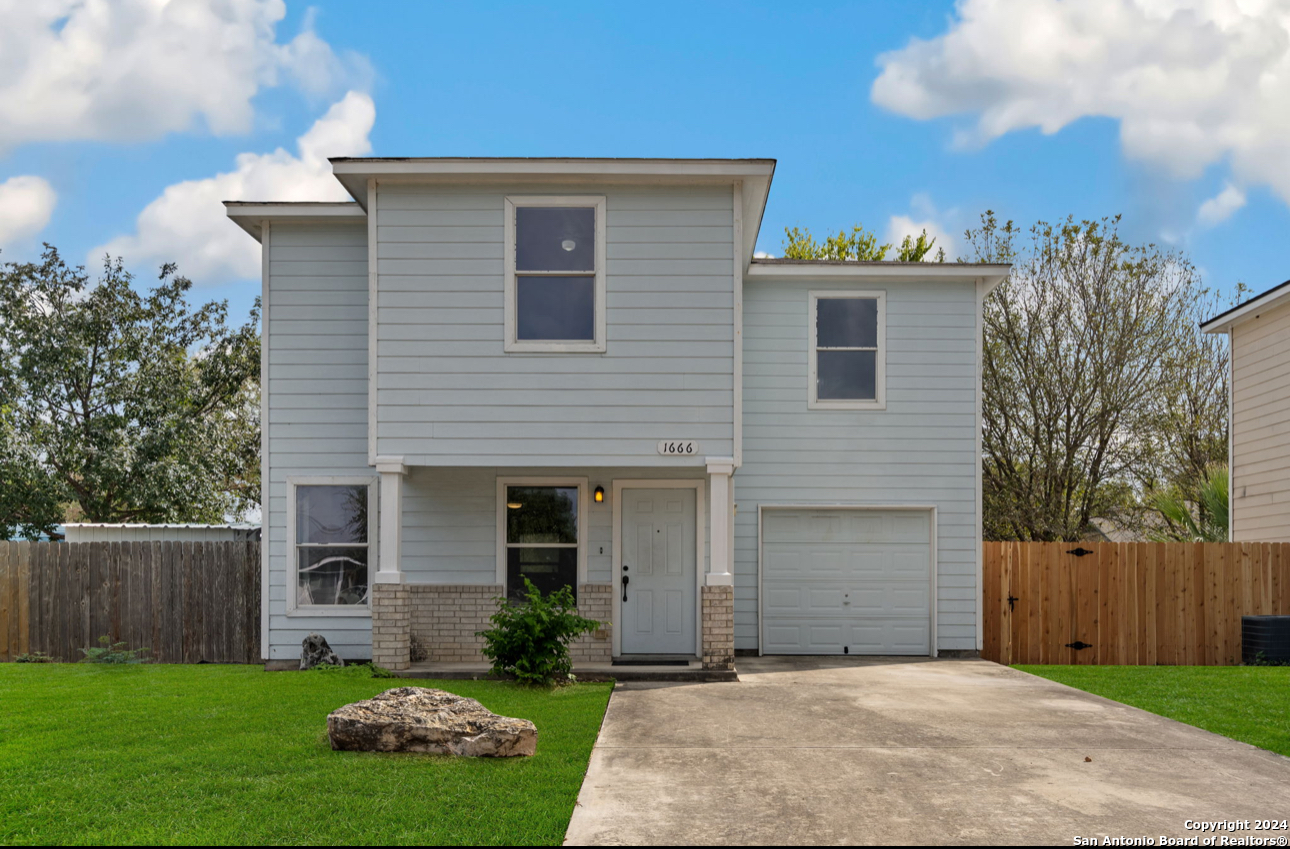 a front view of a house with a yard and garage