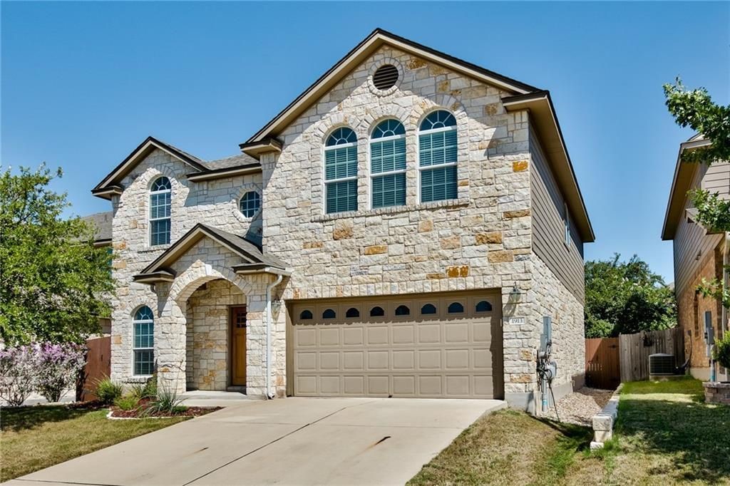 Beautiful stone front with 2 car garage and 2 parking spaces on driveway.