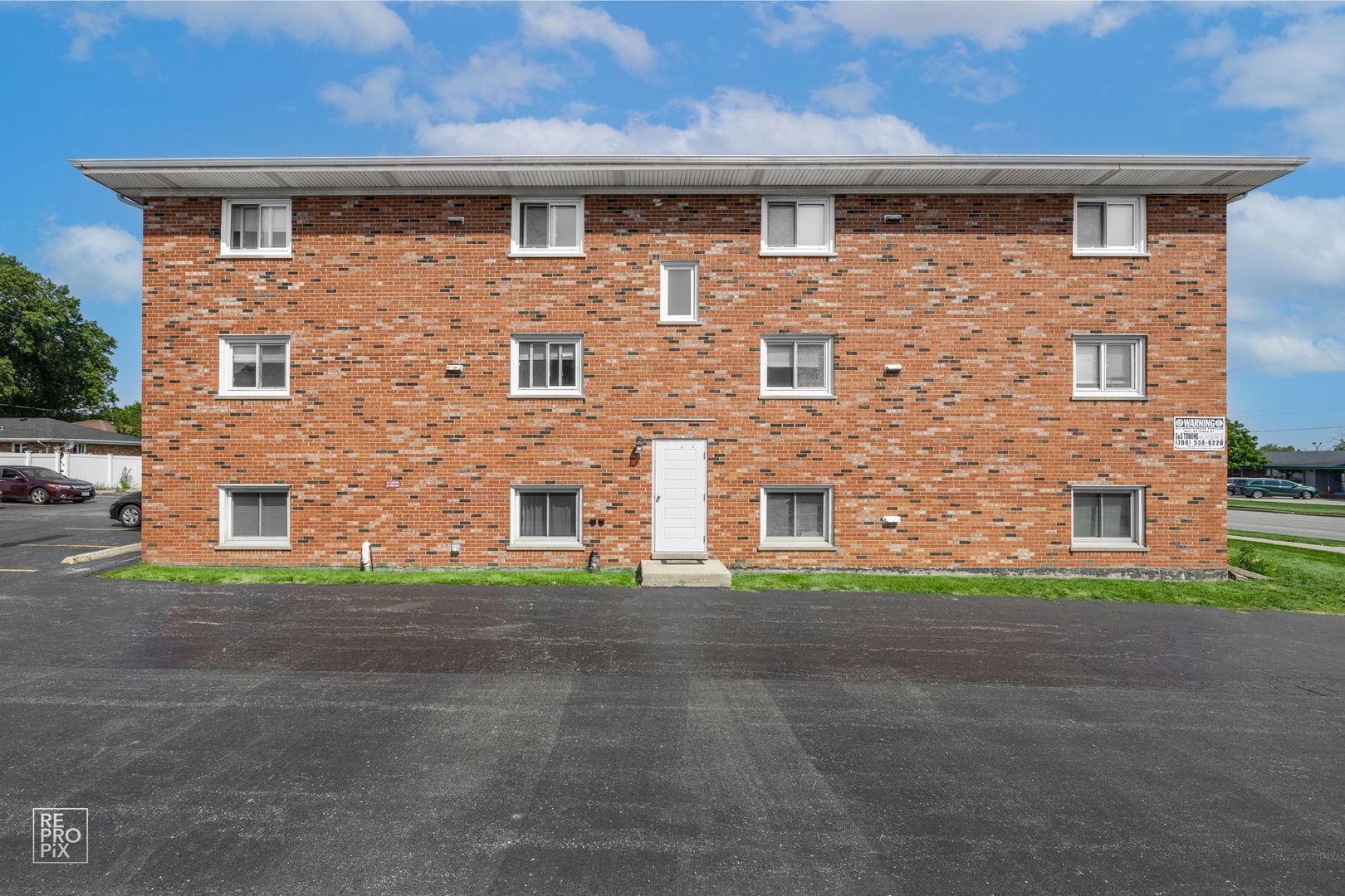 a front view of a building with a yard and garage