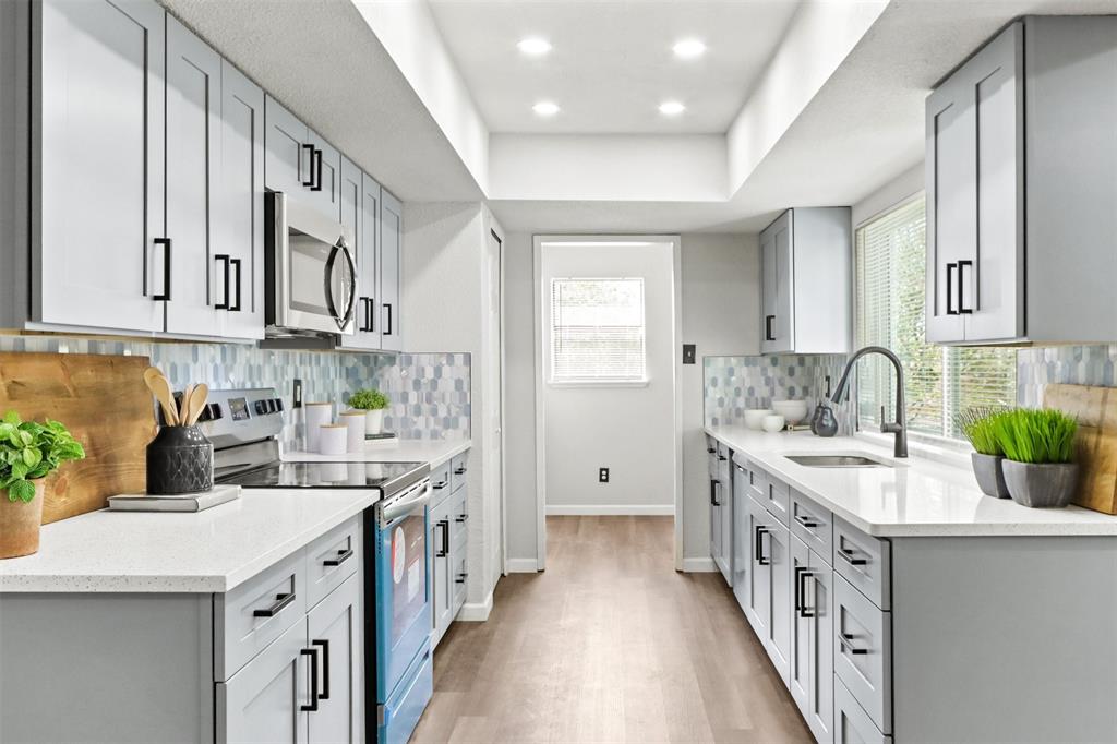 a kitchen with a sink stove and cabinets