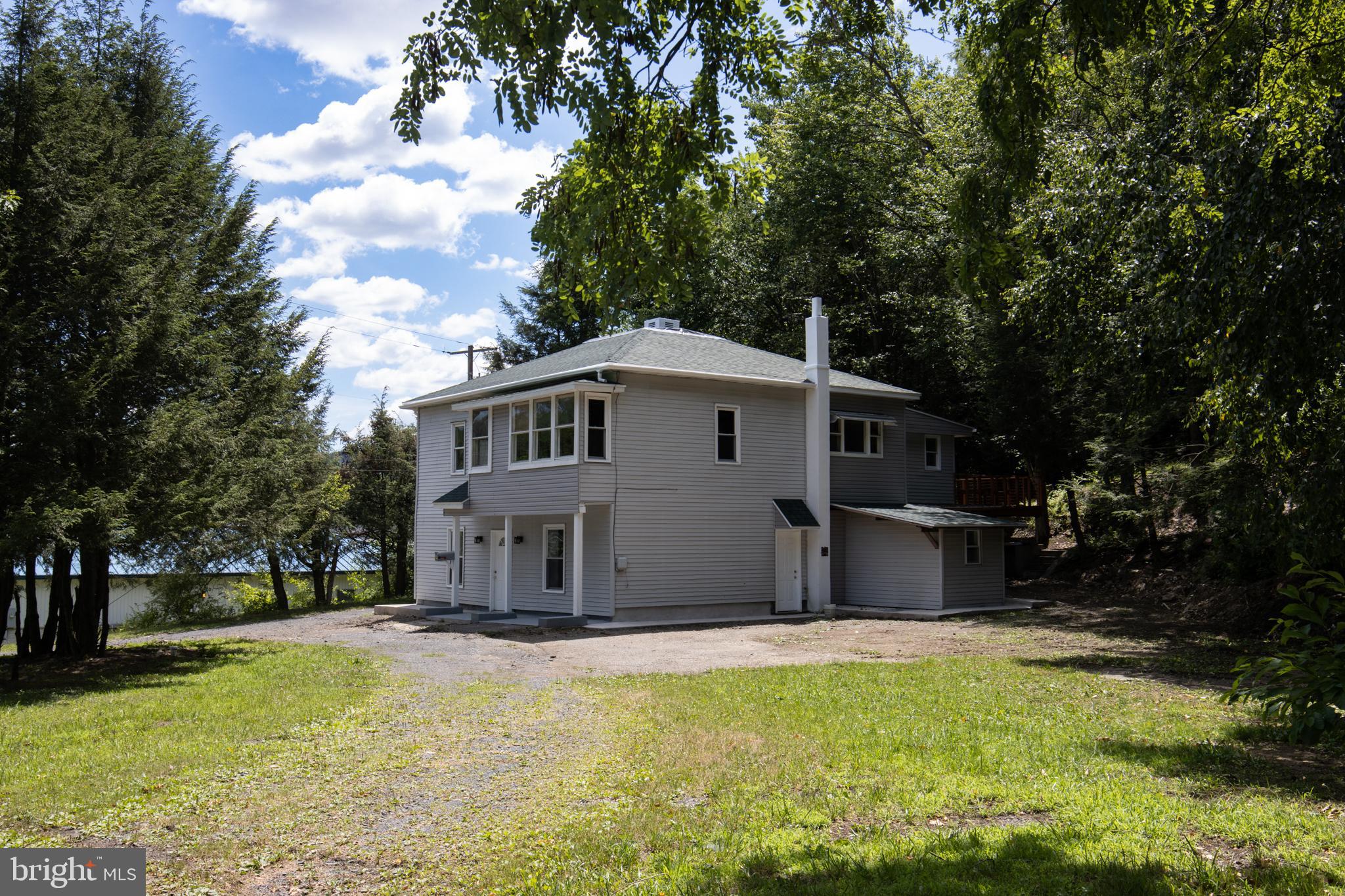 a view of a house with a yard patio and tree