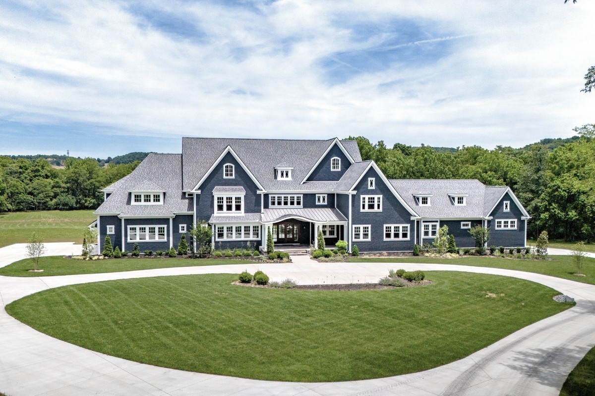 a view of a big house with a big yard and large tree