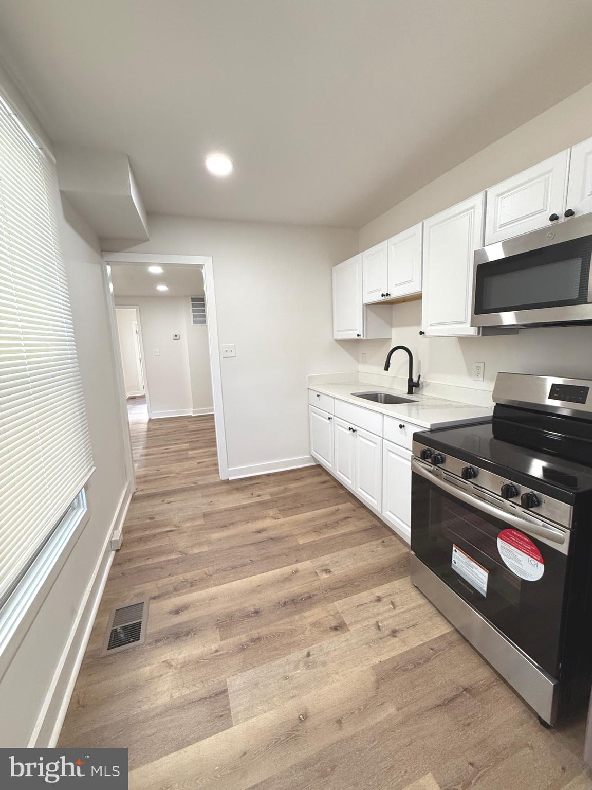 a large kitchen with stainless steel appliances granite countertop a stove and a sink