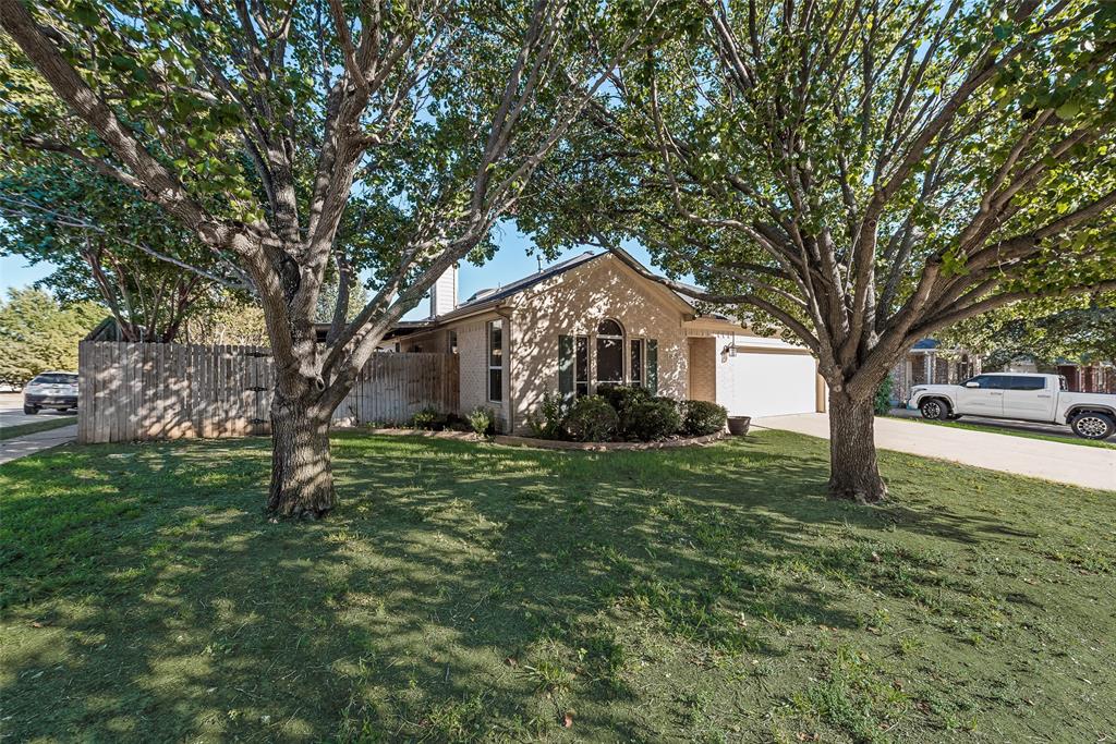 a front view of a house with a yard and trees