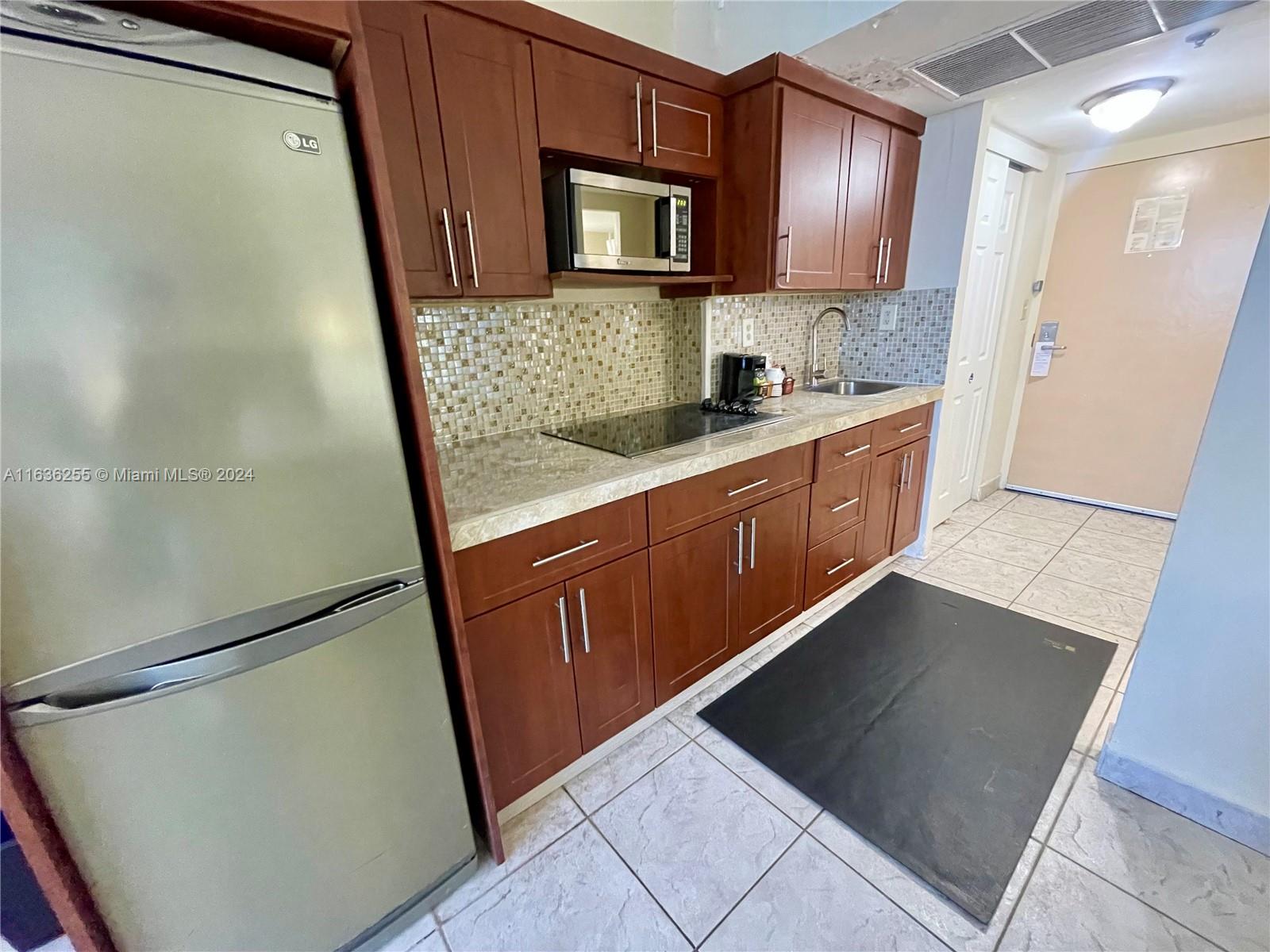 a kitchen with stainless steel appliances granite countertop a refrigerator and a sink