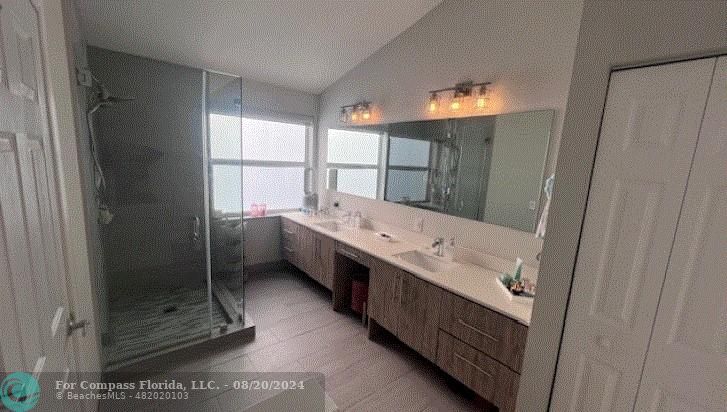 a bathroom with a double vanity sink and mirror