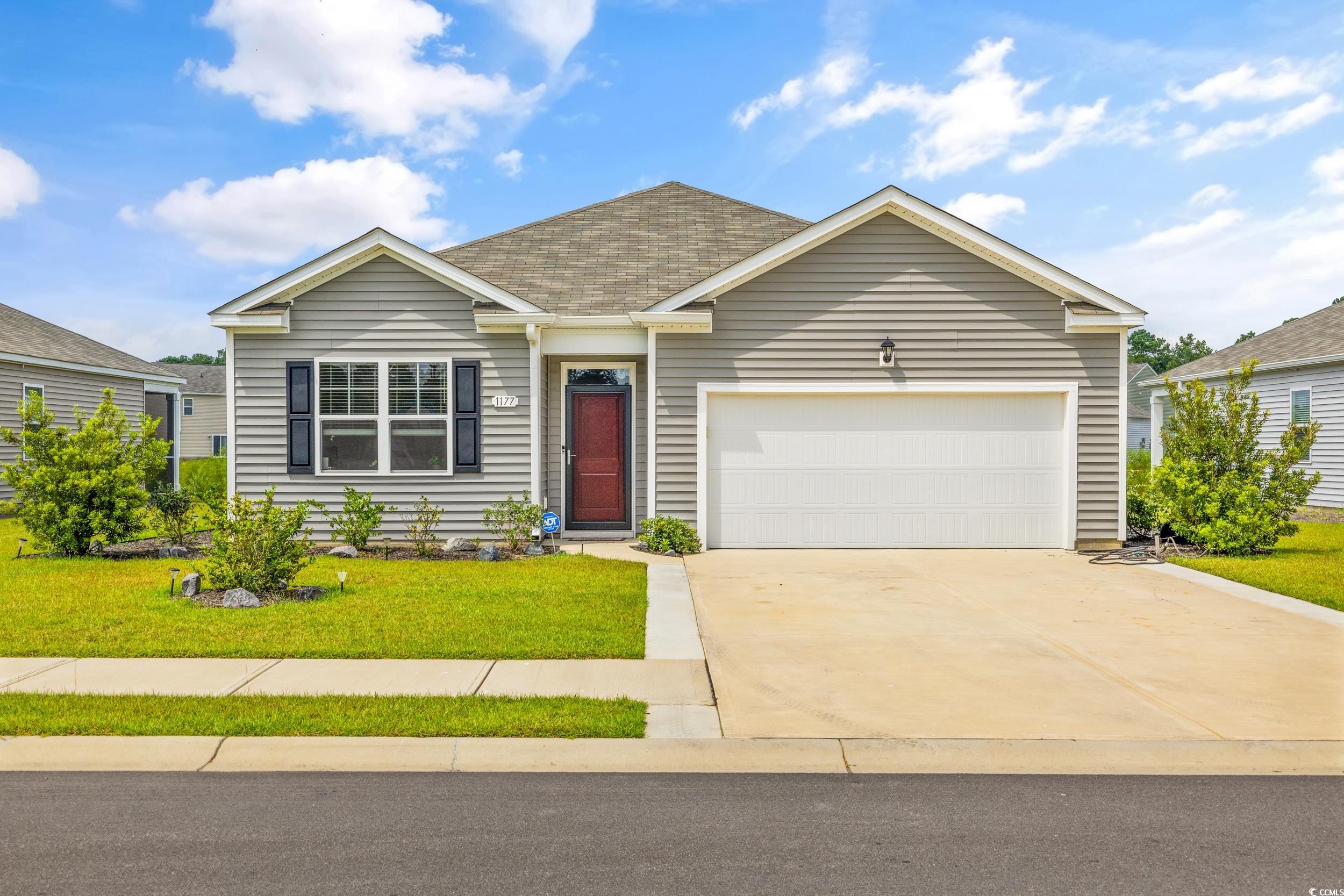 Ranch-style home with a front lawn and a garage