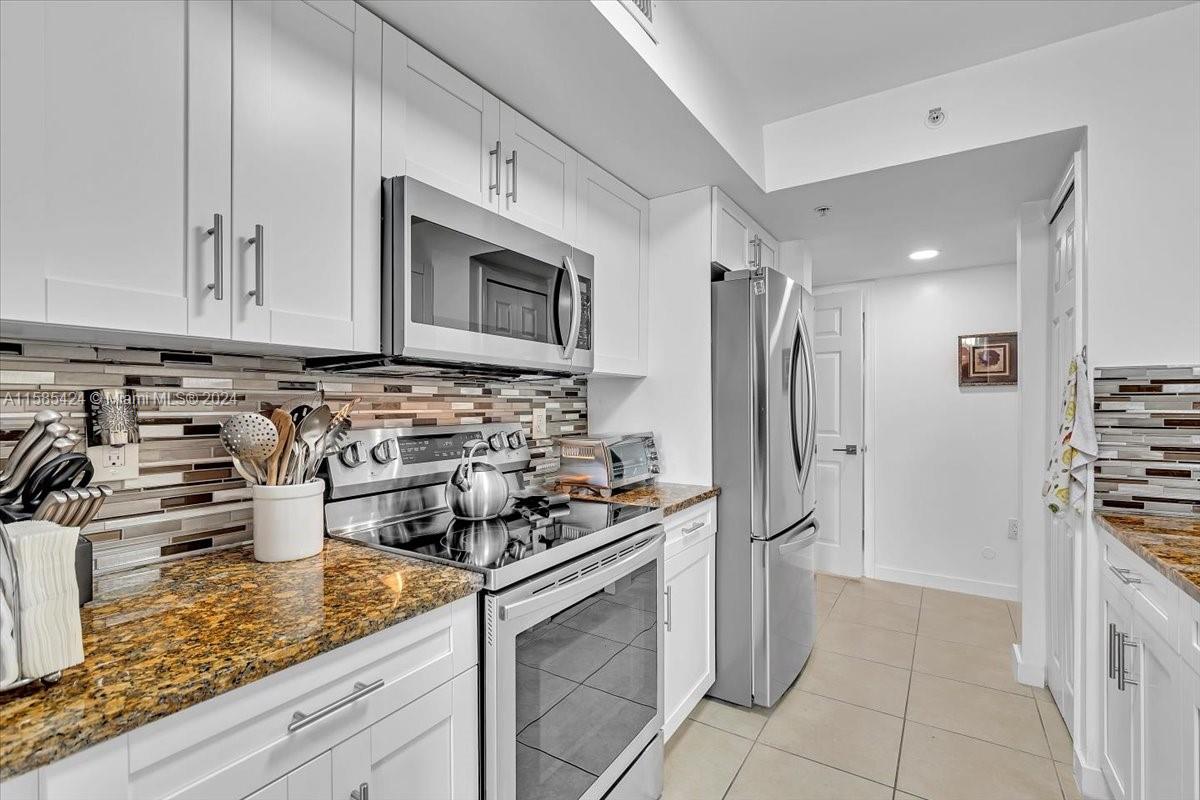 a kitchen with stainless steel appliances granite countertop a stove and a refrigerator