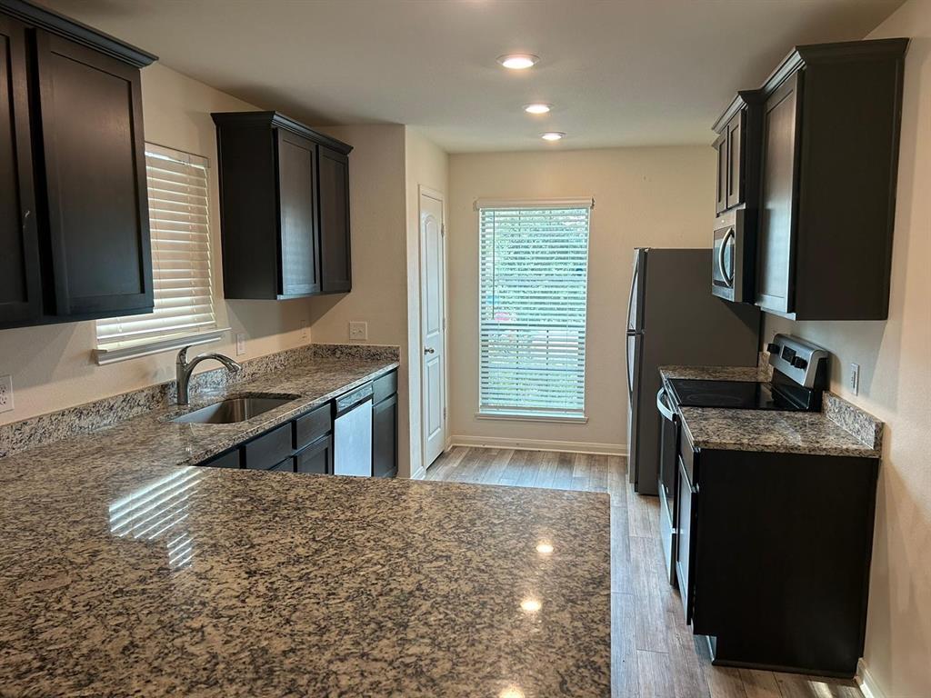 a kitchen with stainless steel appliances granite countertop a sink stove and refrigerator