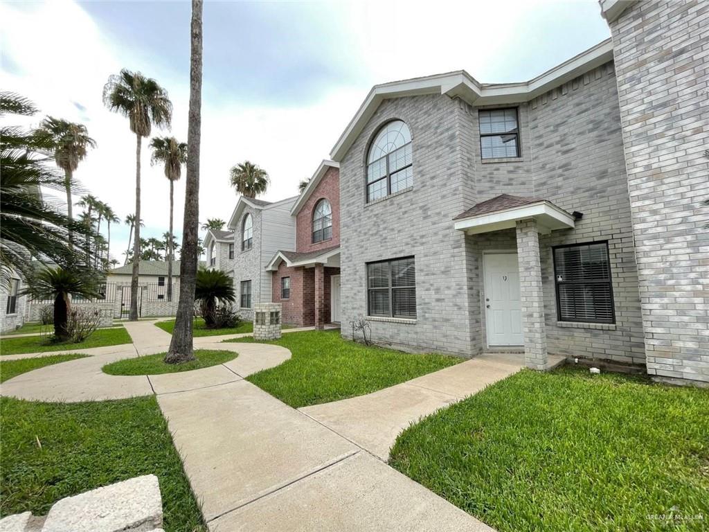 View of front facade with cooling unit and a front lawn