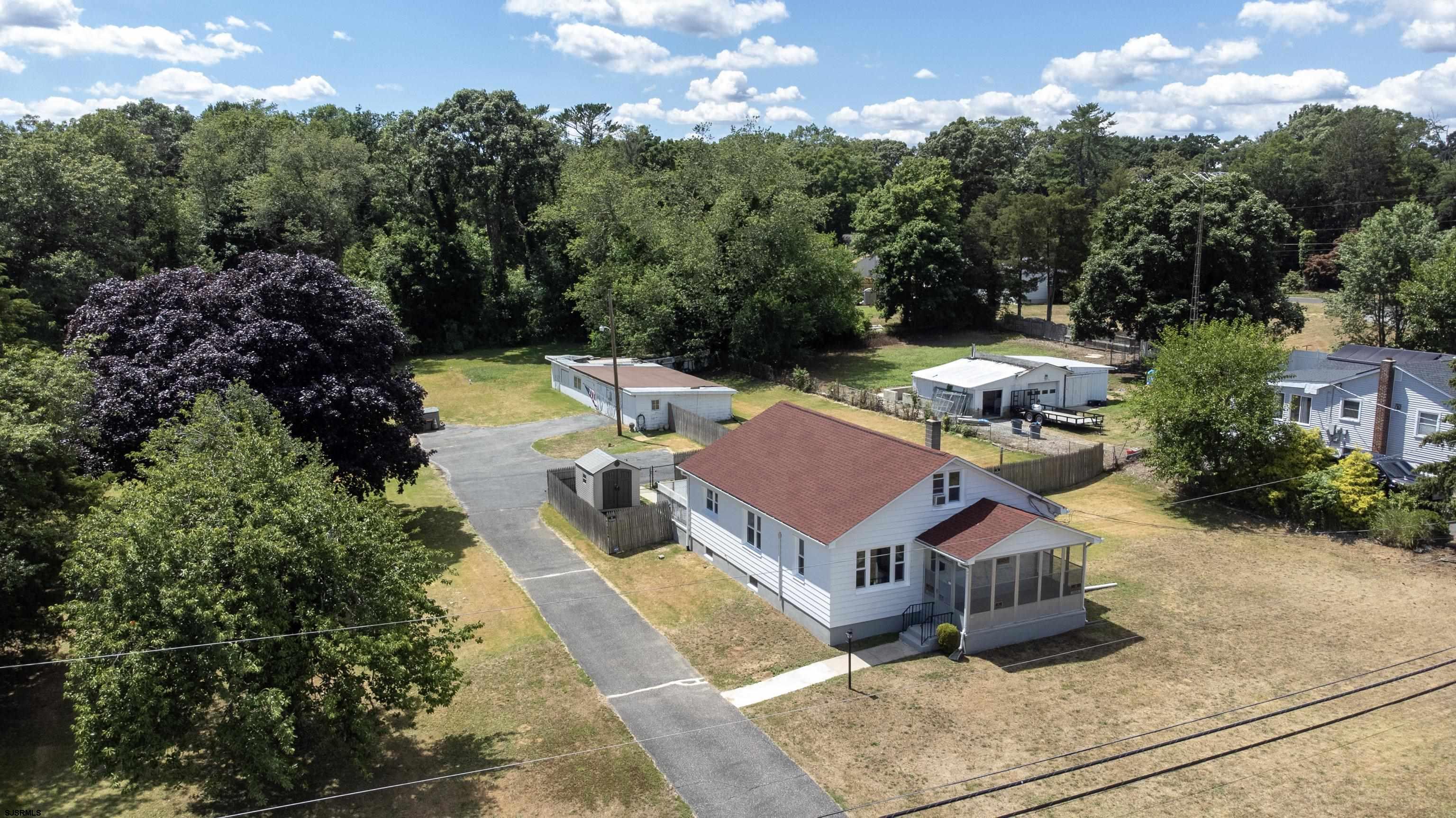 an aerial view of residential houses with outdoor space and trees