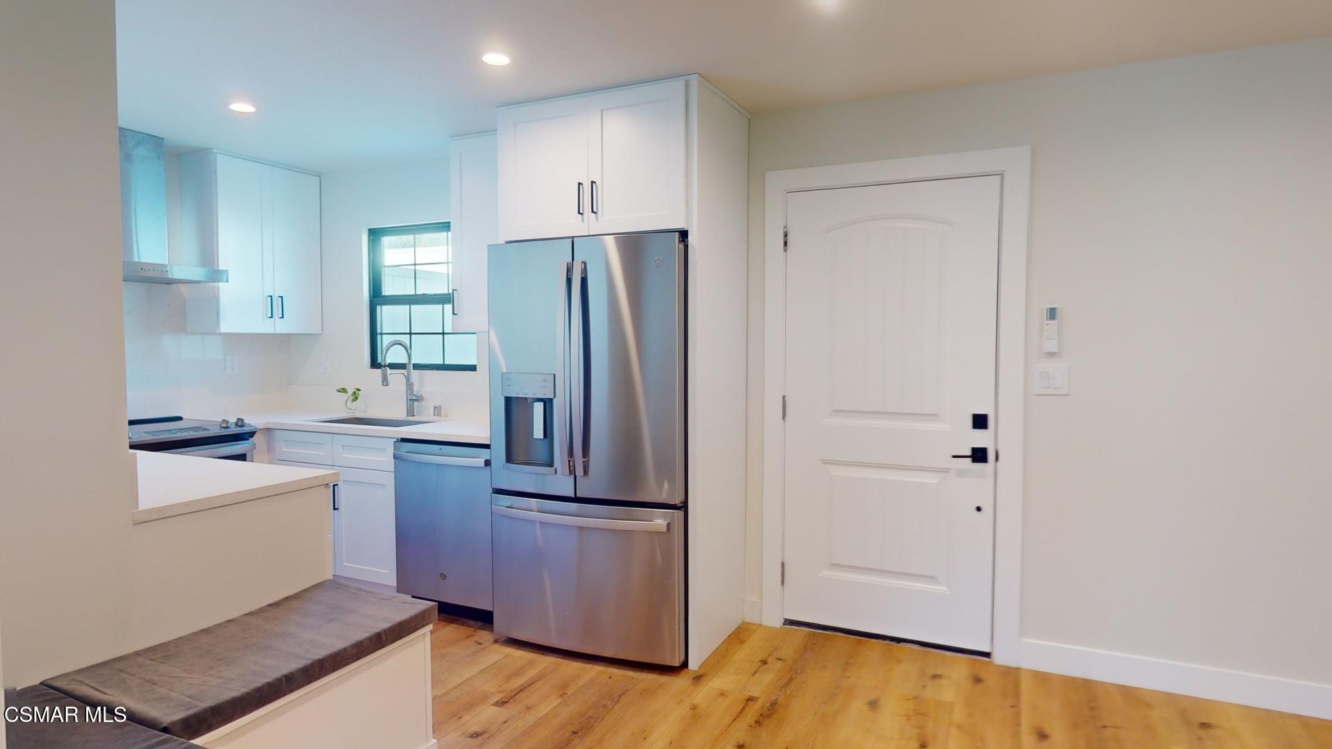 a kitchen with a refrigerator sink and cabinets