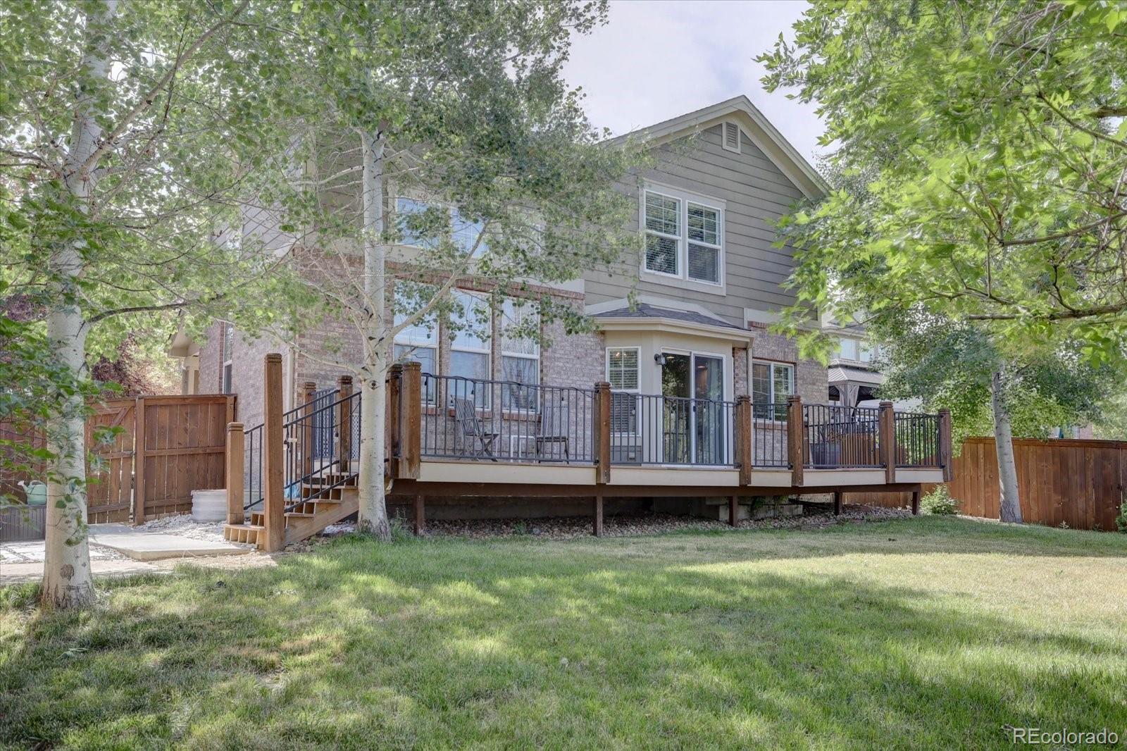 a view of a house with a yard and wooden fence