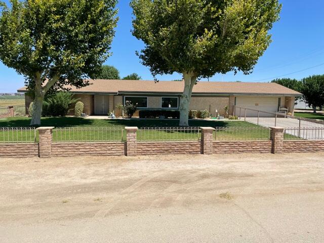 a view of a house with backyard and a tree