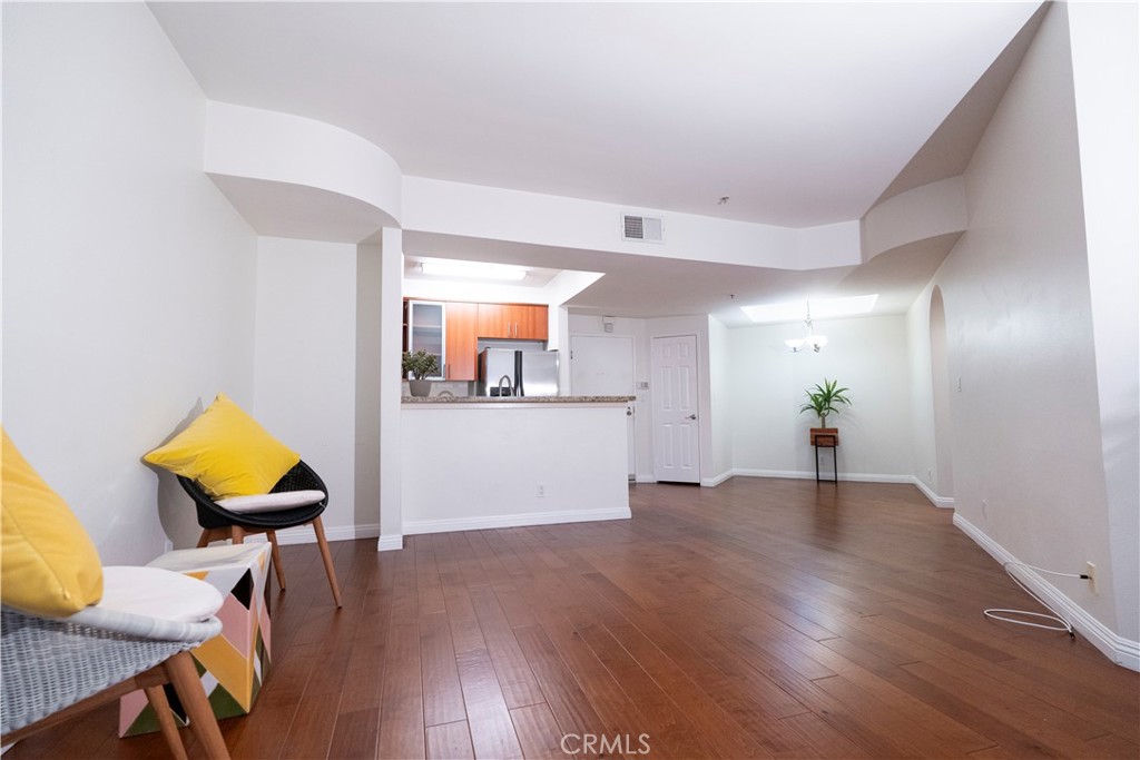 a view of a livingroom with wooden floor and a workspace