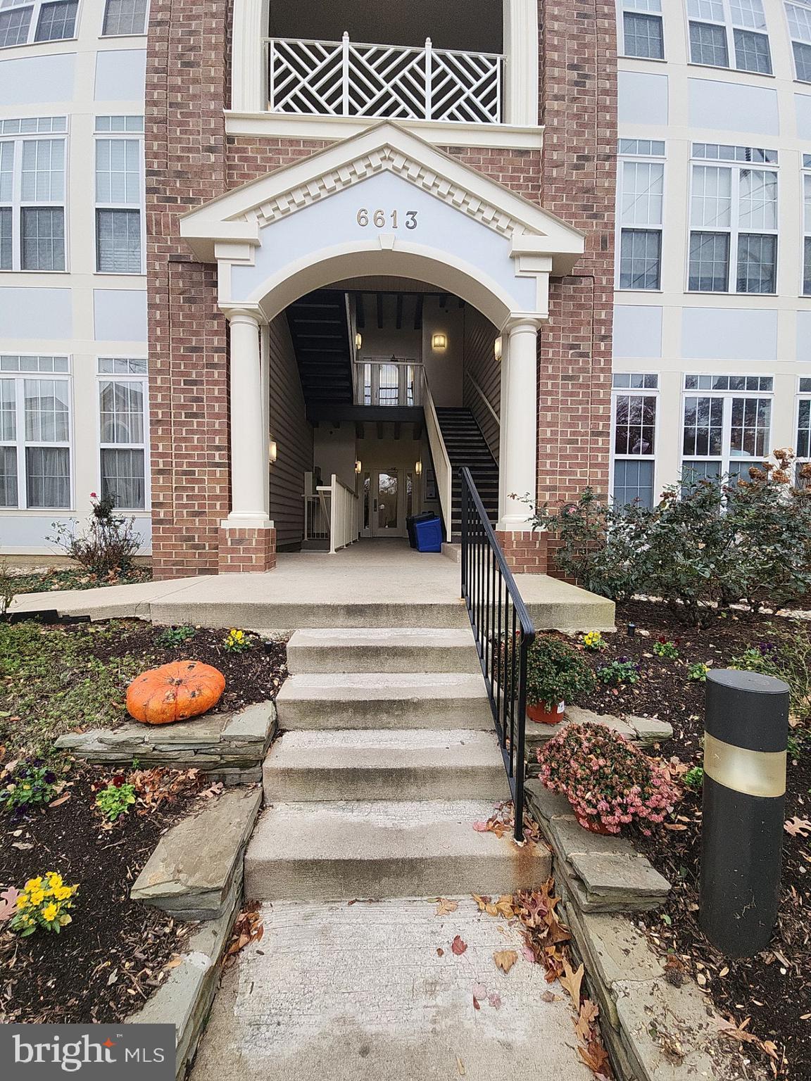 a view of a brick house with entryway and a rug