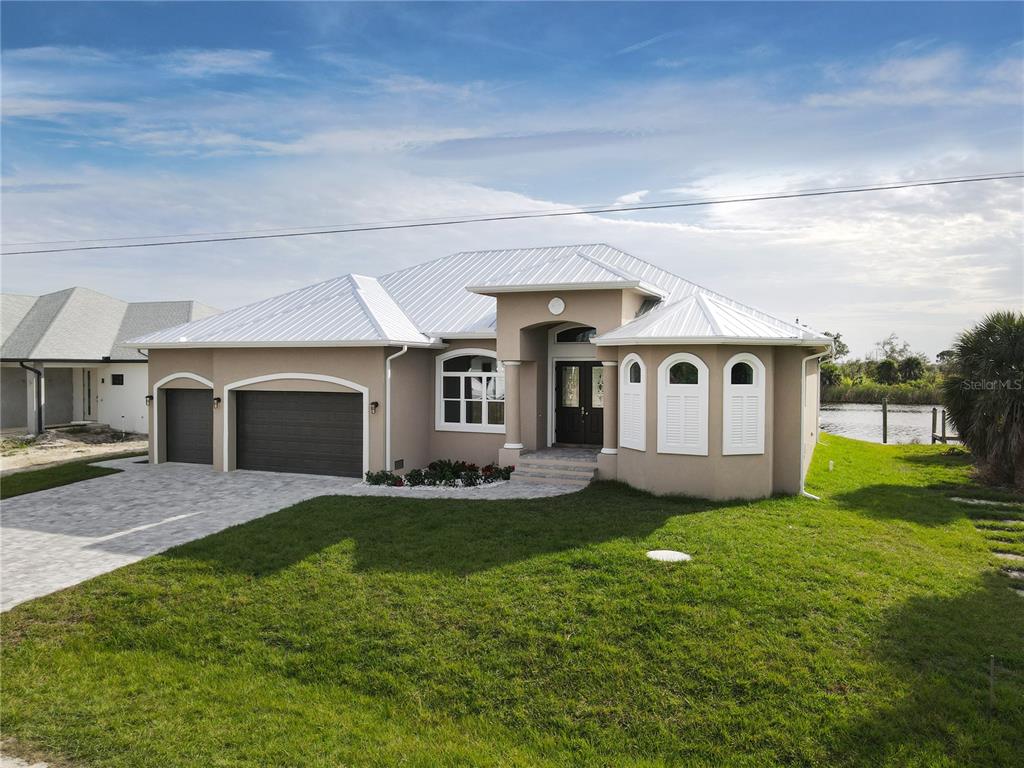 a view of a house with a yard and a garage