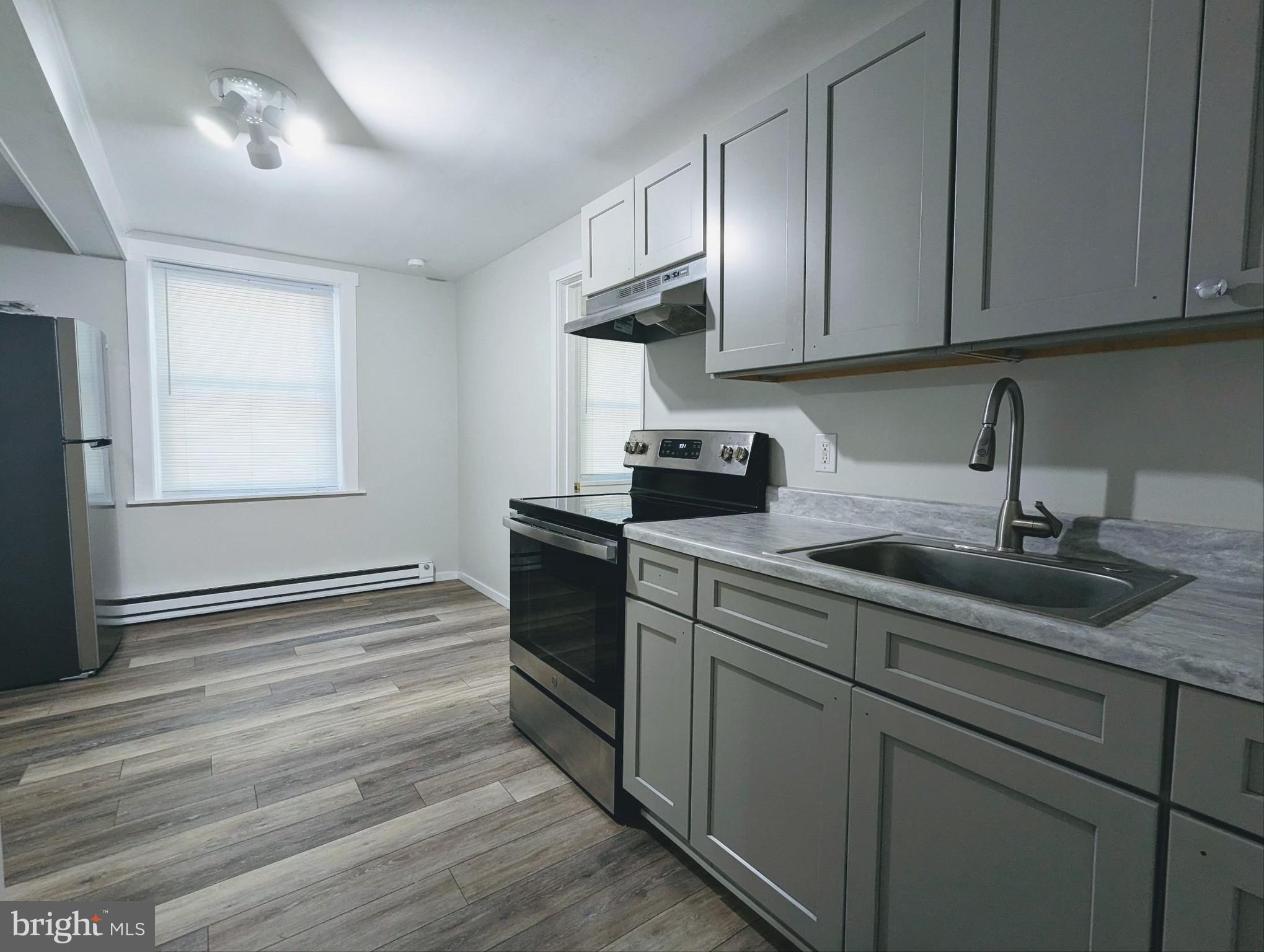 a kitchen with granite countertop wooden cabinets stainless steel appliances and a sink