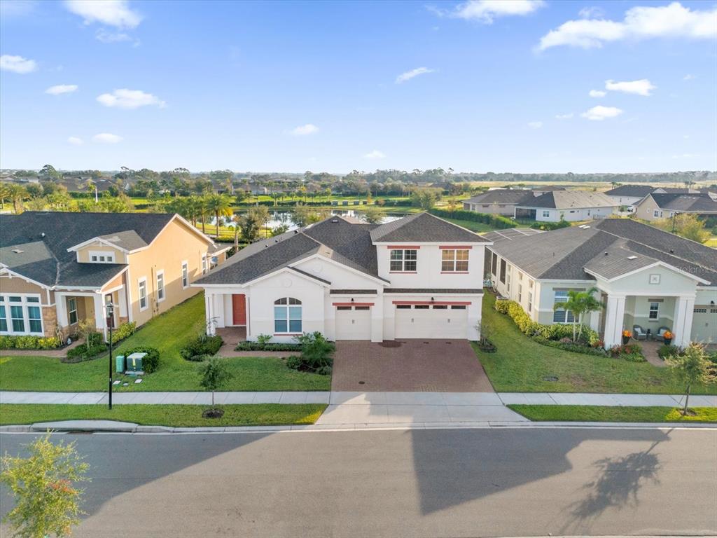 an aerial view of a house with a big yard and palm trees